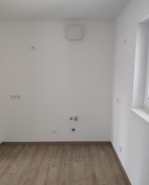 Feistkornstraße 9a 4 helle Küche mit Tageslicht, grau/beigen Bodenbelag und weißen Wänden, Wasseranschlüsse und Lüfter